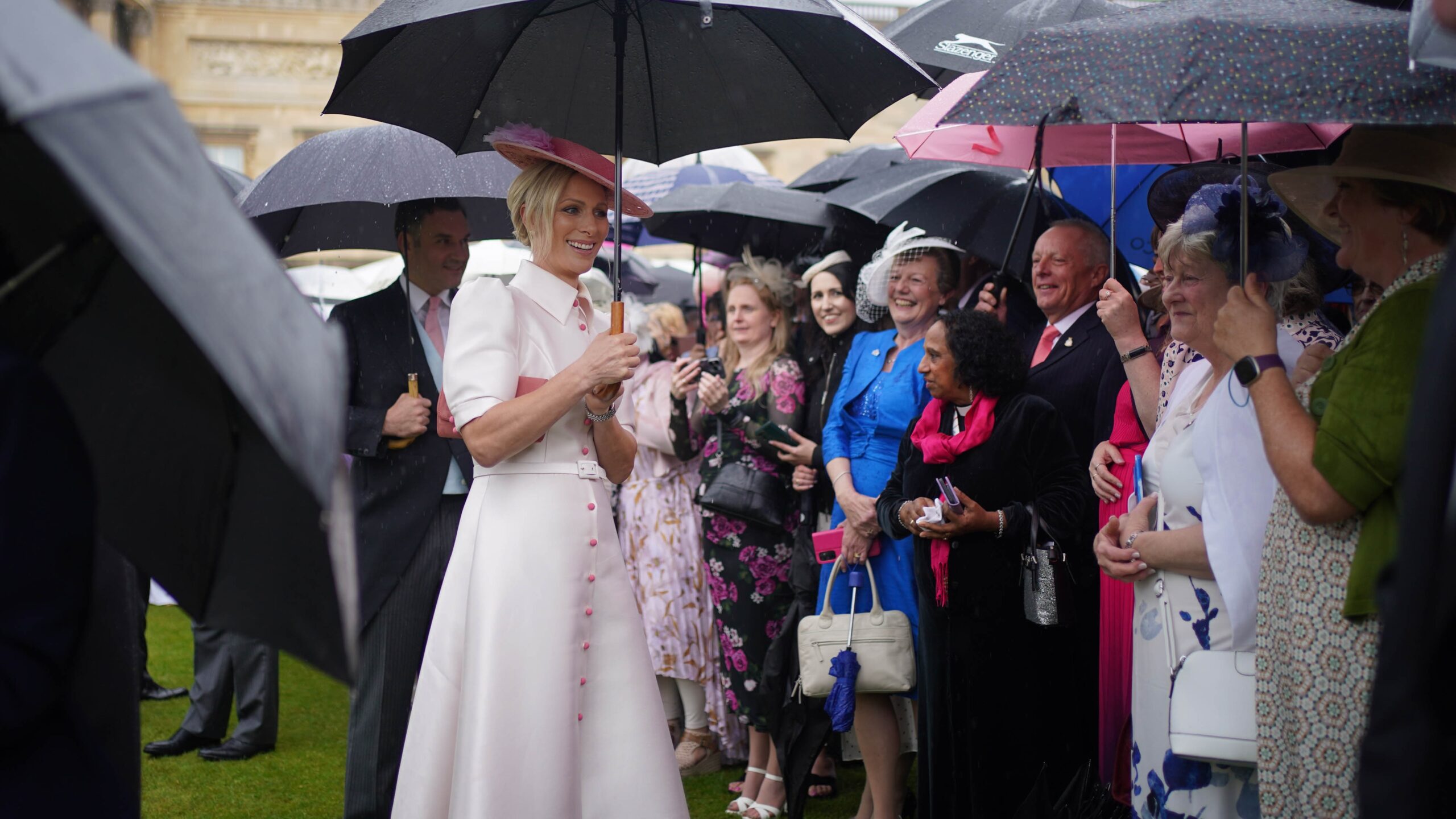 Zara Tindall holds an umbrella as she attends the Sovereign's Garden Party at Buckingham Palace on May 21, 2024