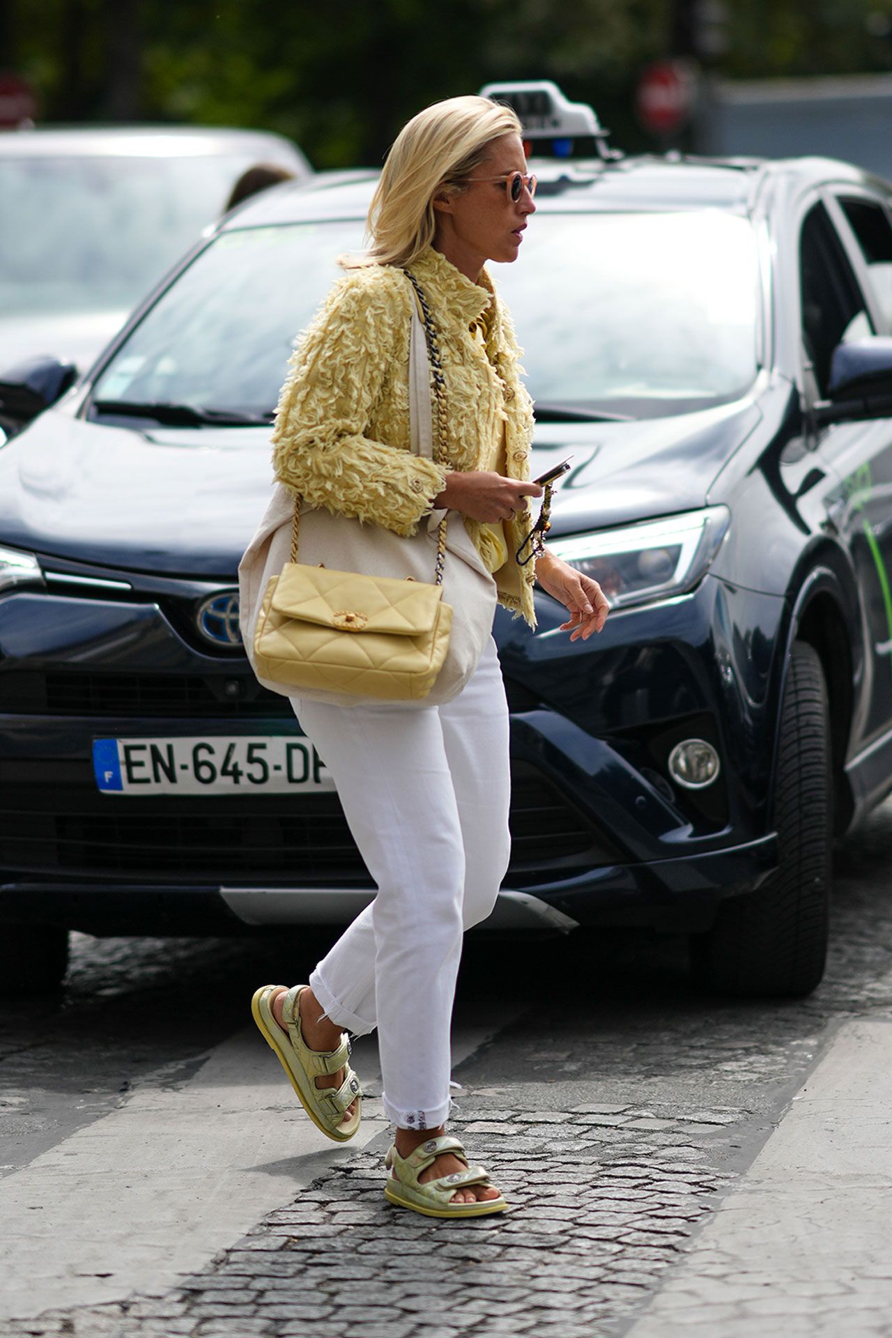 Image may contain Clothing Footwear Sandal Shoe Accessories Bag Handbag Adult Person Pedestrian and Car