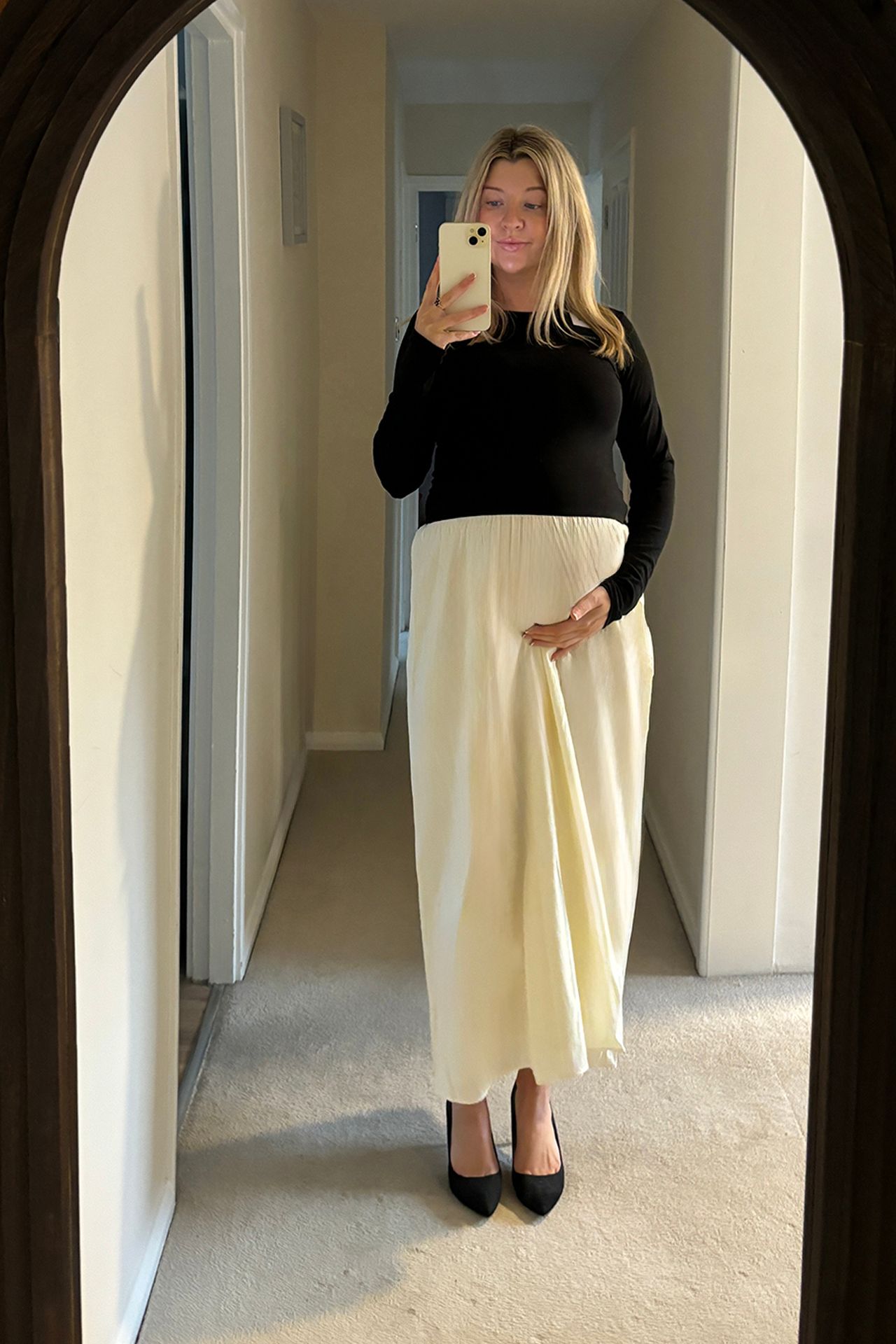 Image may contain Person Clothing Skirt Adult Electronics Mobile Phone Phone Sleeve and Standing