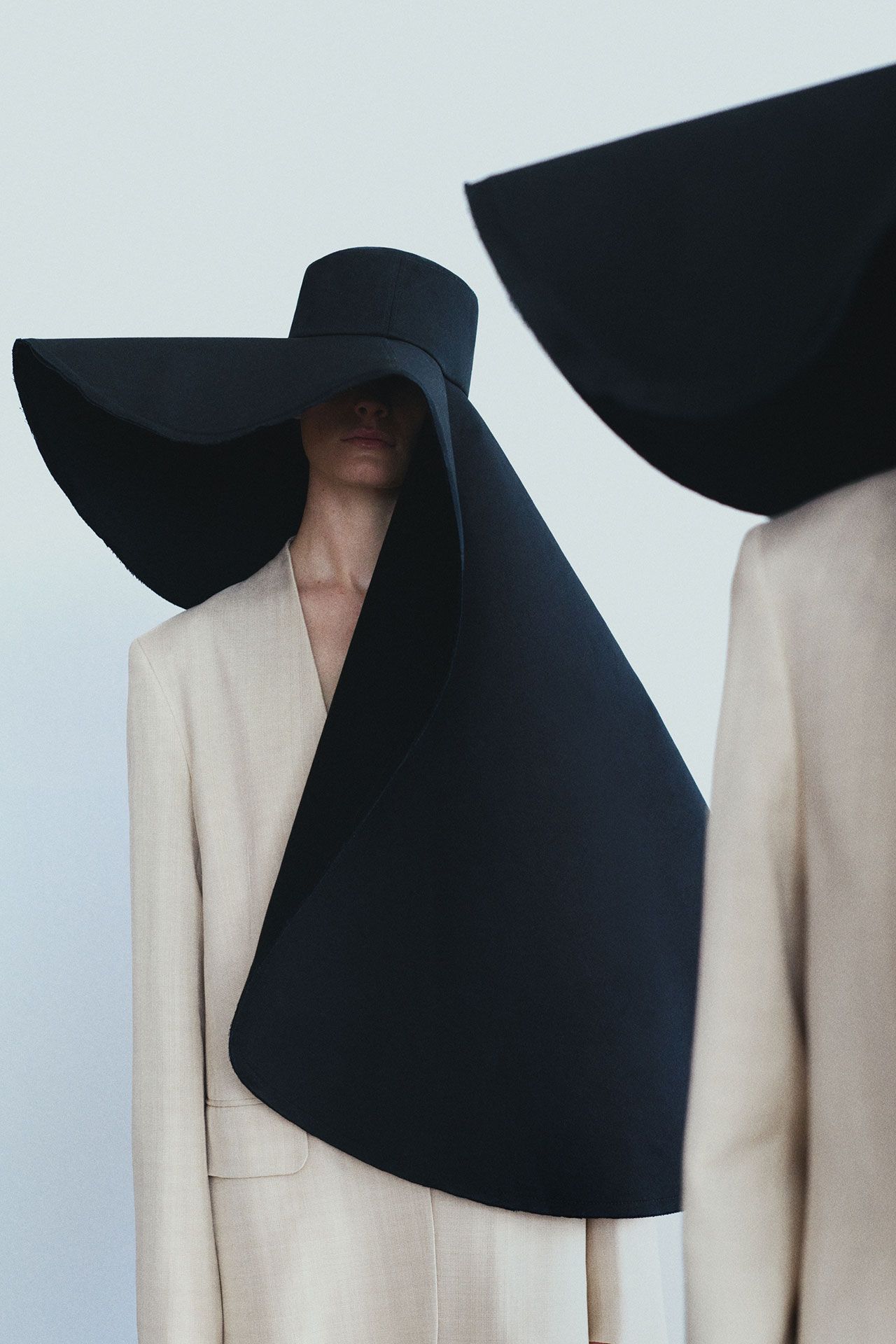 Image may contain Clothing Hat Coat Cape Blazer Jacket and Formal Wear