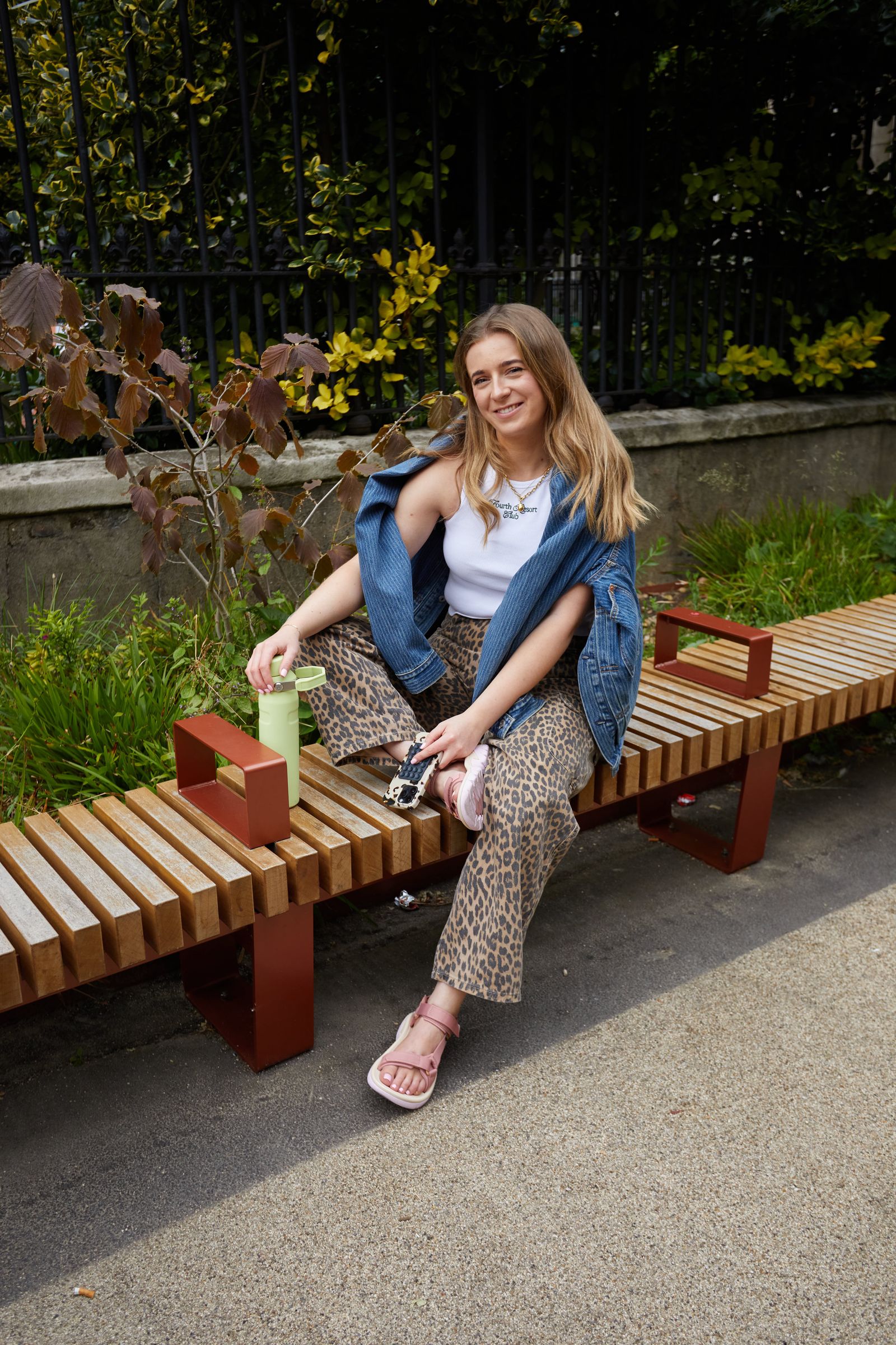 Image may contain Person Sitting Bench Furniture Face Head Photography Portrait Clothing Pants and Footwear
