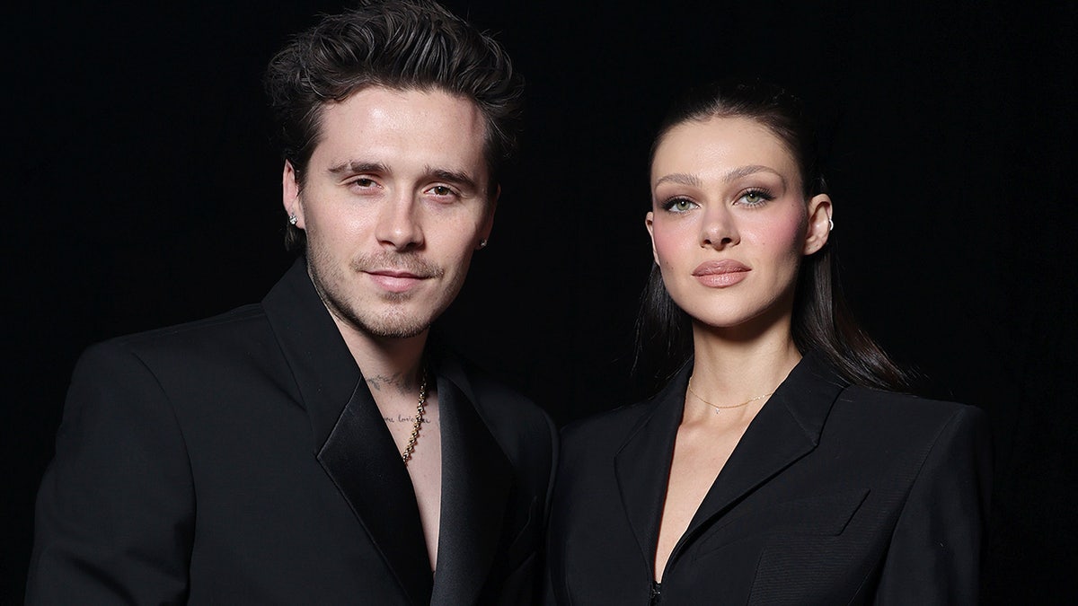 A close-up of Brooklyn Beckham and Nicola Peltz wearing matching black outfits.