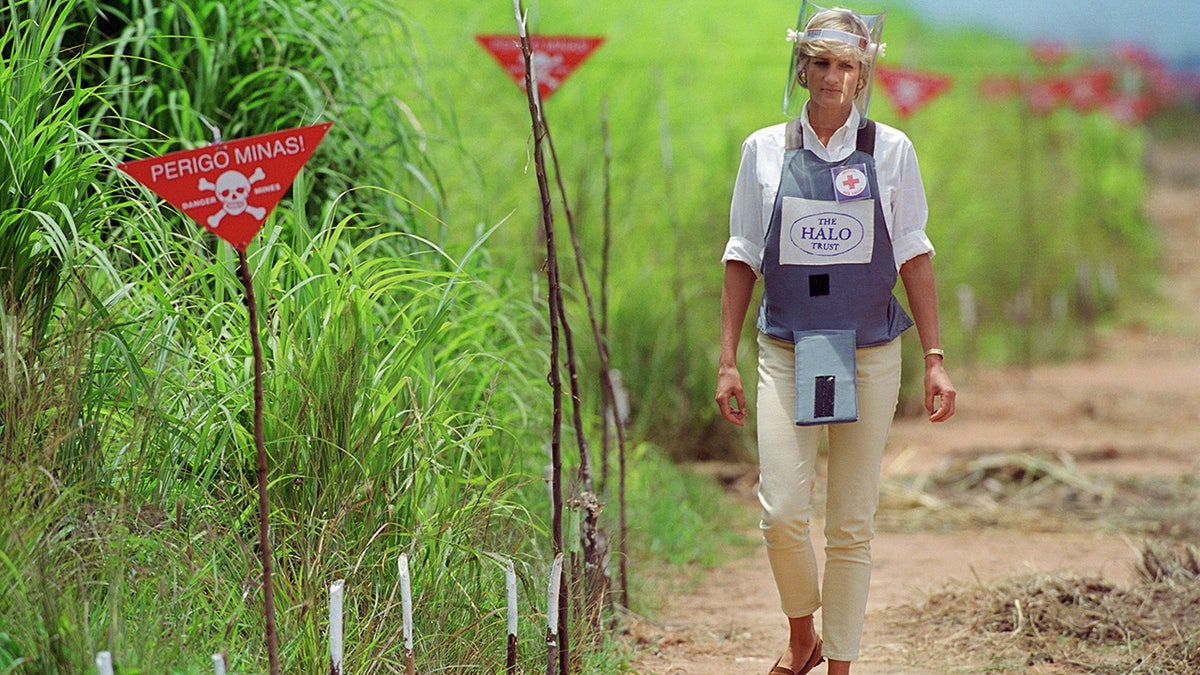 Princess Diana walking through a landmine in protective gear.