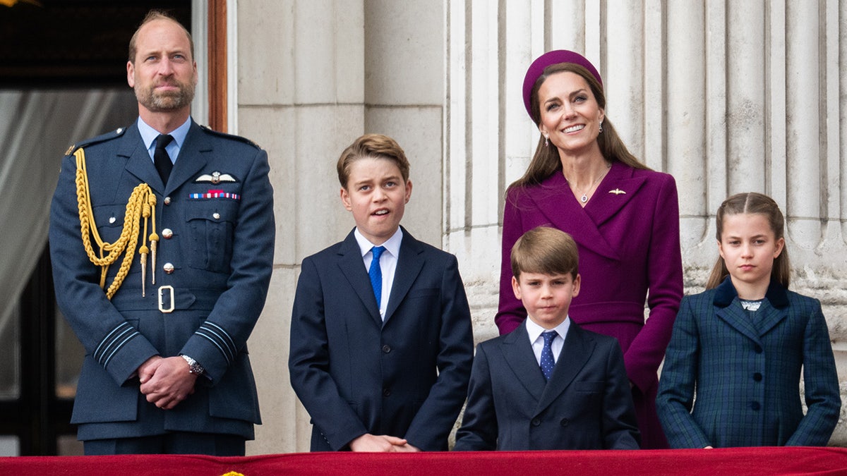 Prince William and Kate Middleton standing on the Buckingham Palace balcony with their three children.