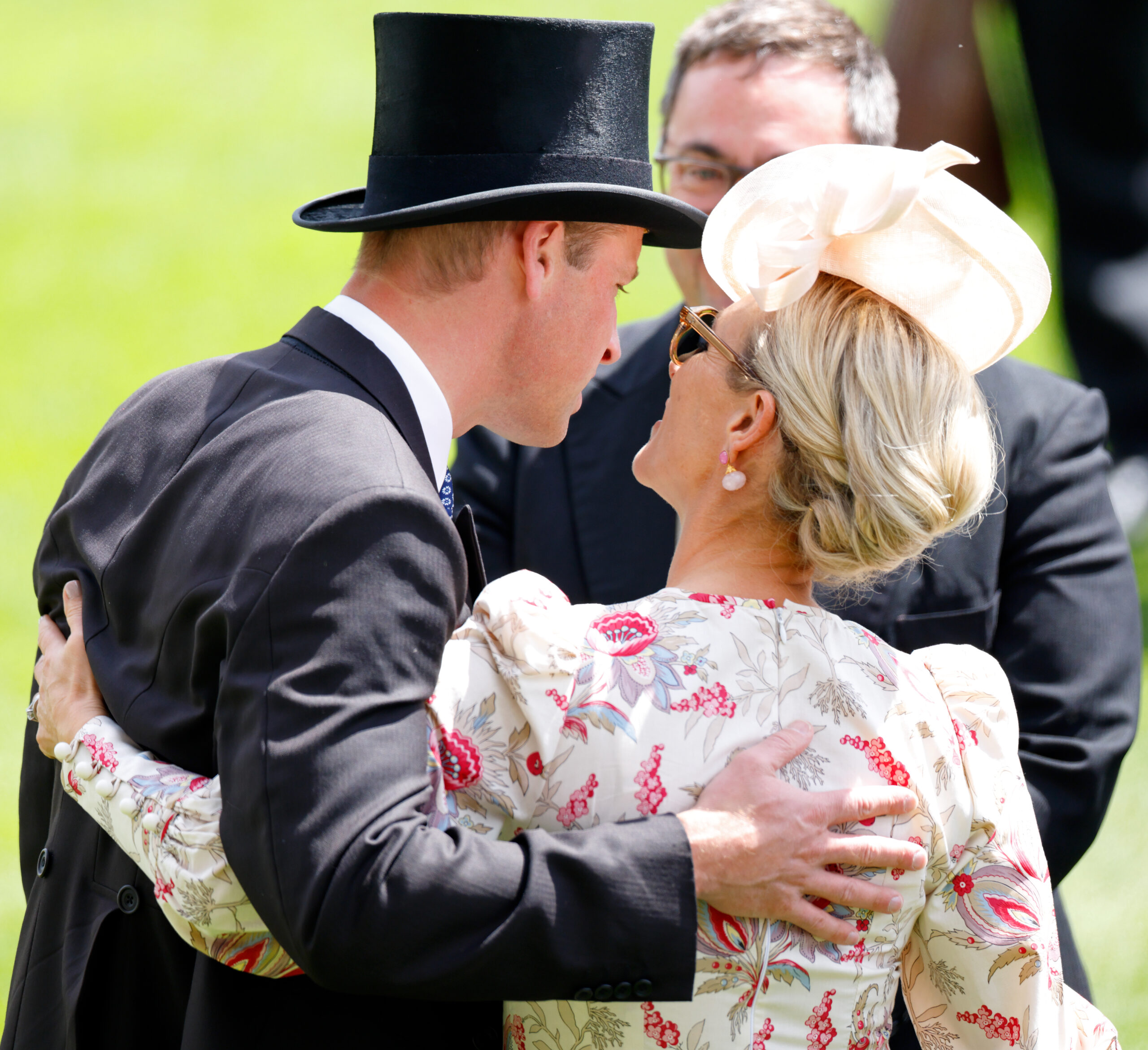 Prince William wearing a top hat with his arm around Zara Tindall