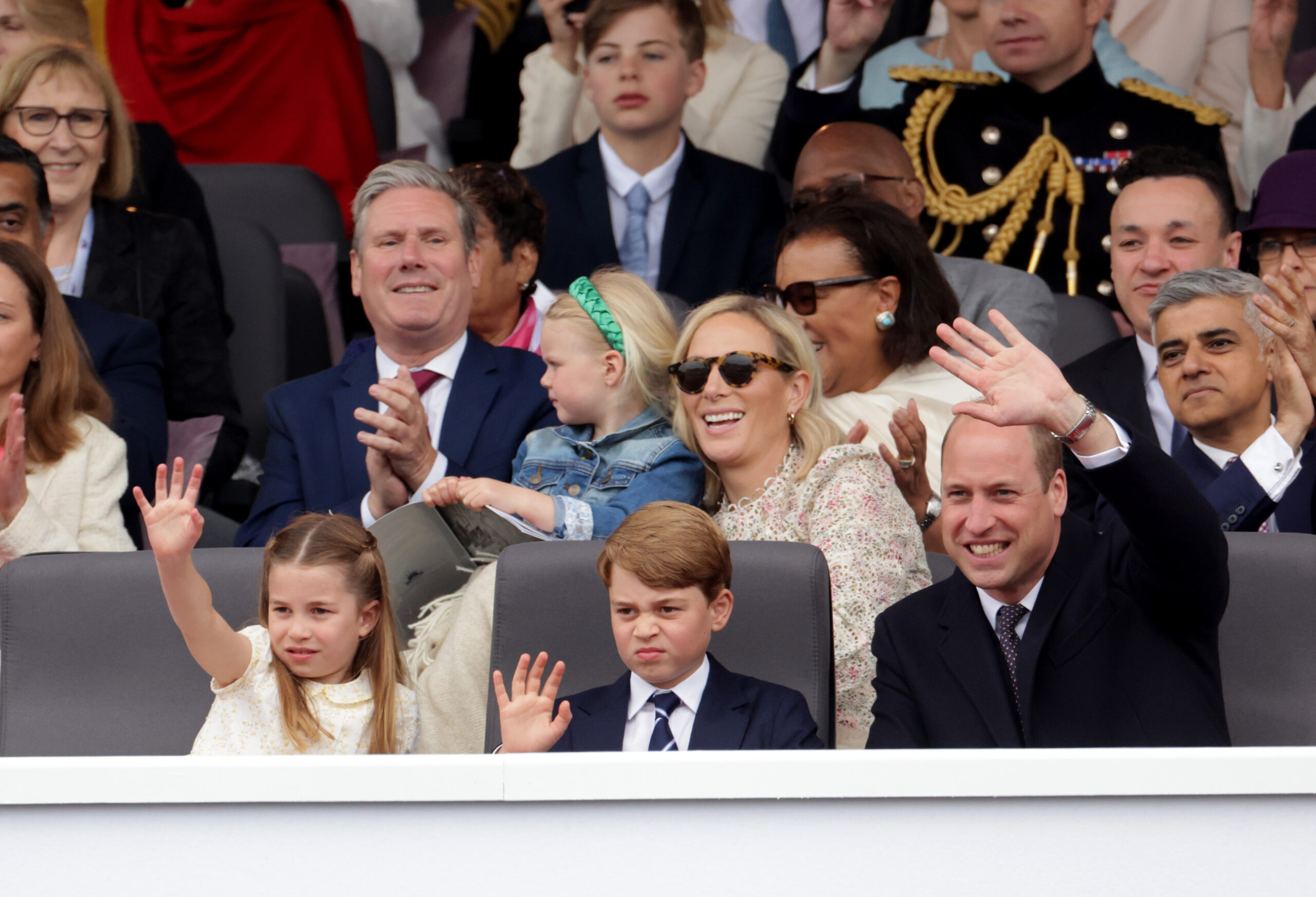 Zara Tindall sitting behind Prince William, Princess Charlotte and Prince George, who are waving