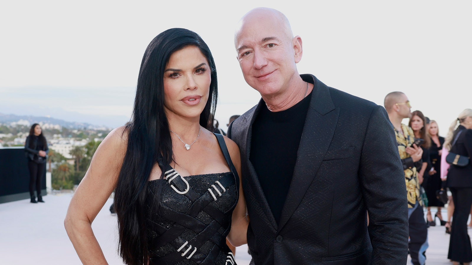 Image may contain Jeff Bezos Laura Snchez Blazer Clothing Coat Jacket Person Photobombing Fashion and Accessories
