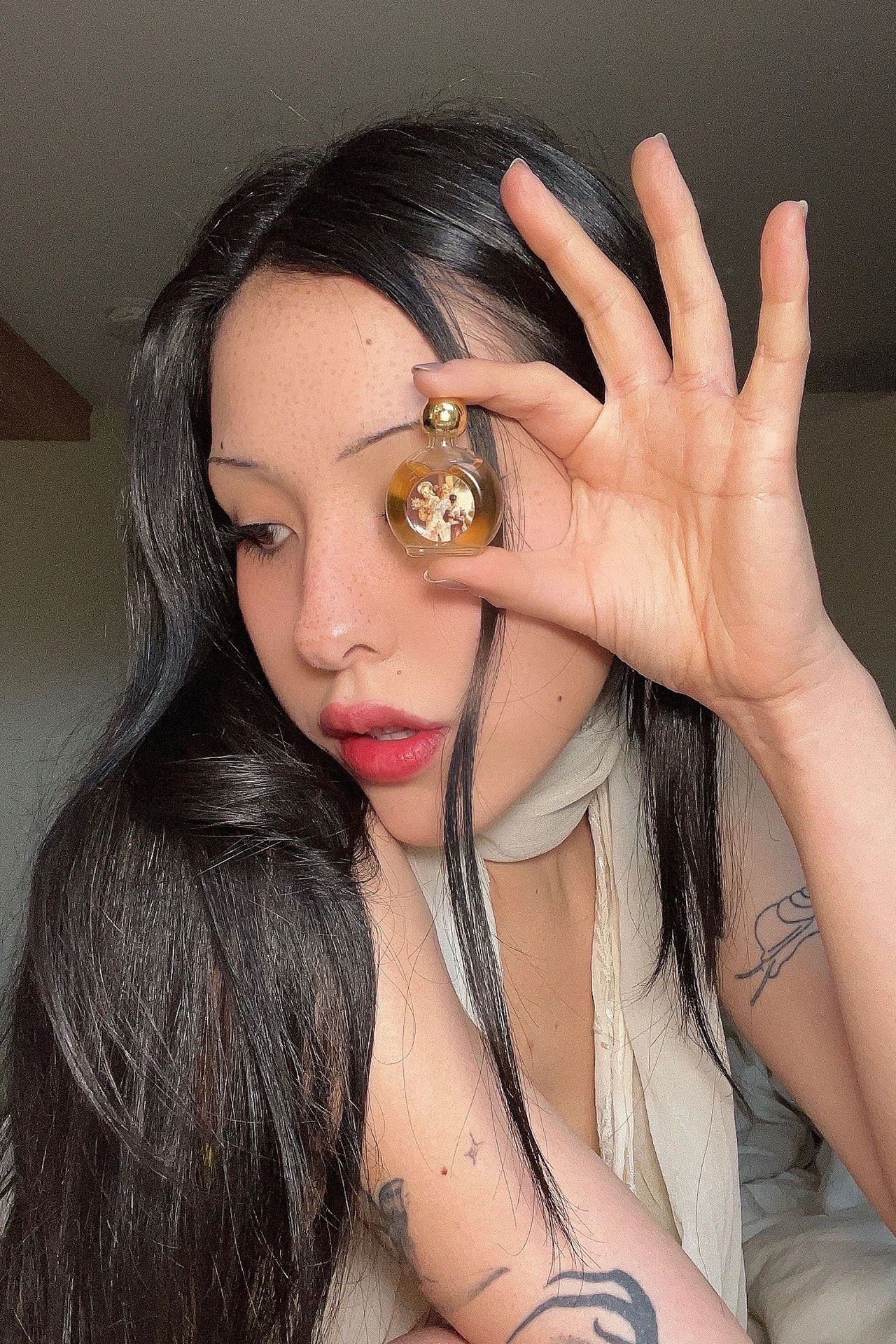 Image may contain Face Head Person Photography Portrait Bottle Cosmetics Perfume Adult Black Hair and Hair