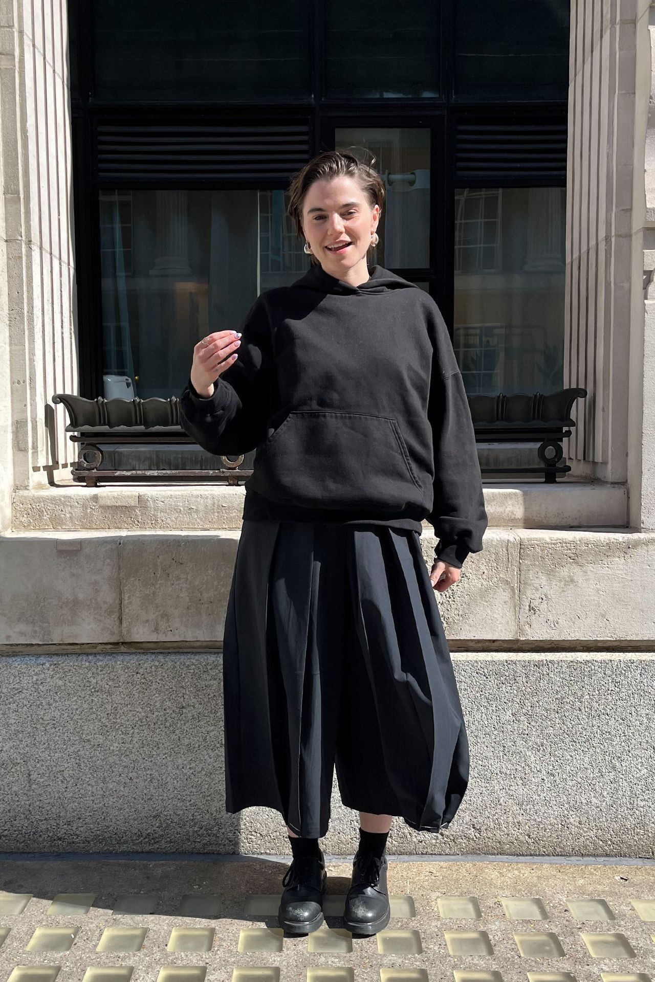 Image may contain Person Clothing Hoodie Knitwear Sweater Sweatshirt and Standing