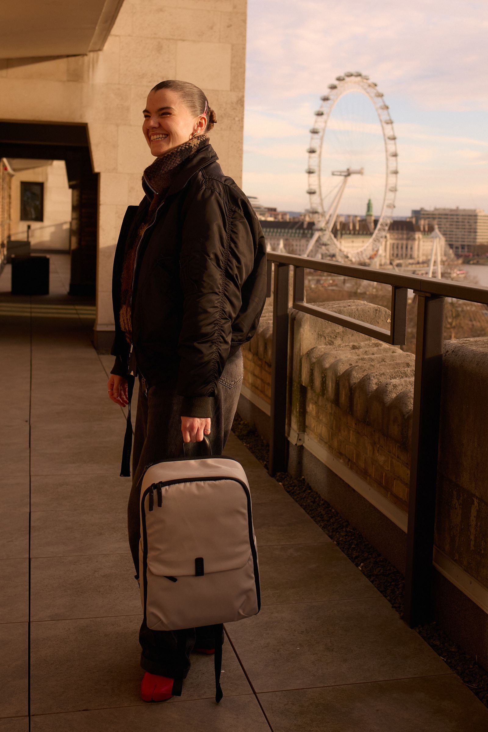 Image may contain Clothing Coat Adult Person Face Head Photography Portrait Walking Backpack Bag and Footwear