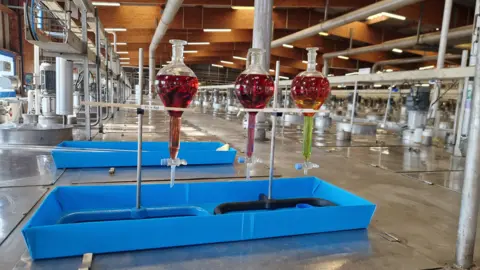 BBC / Jonathan Josephs Vials show demonstrate how neodymium and praseodymium are separated from a mixture of rare earths in the vast vats that fill the room  