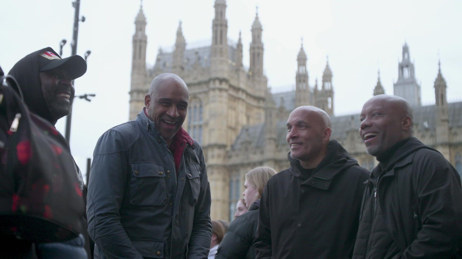 Members of the V11 group are standing outside the Houses of Parliament for a campaign march.