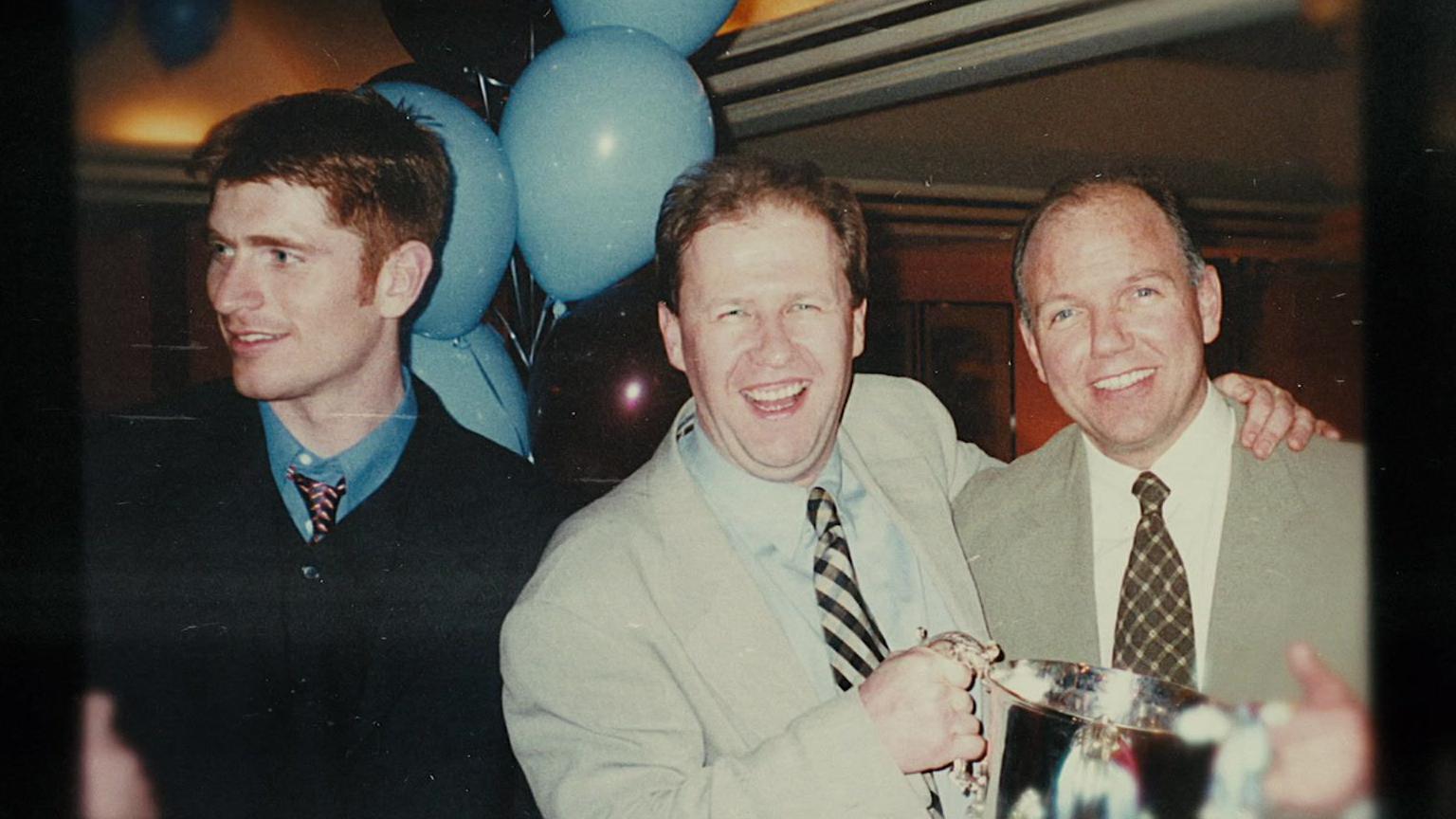 David McKee and Kevin McMenamin pose holding the League Cup trophy stood alongside Tommy Johnson. 