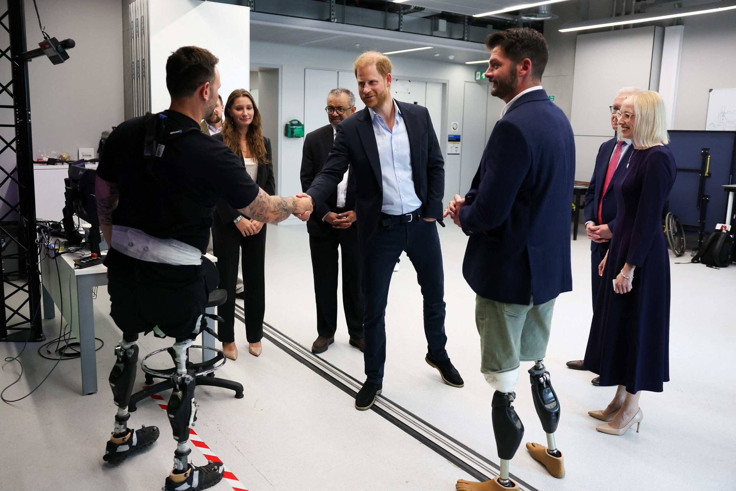 Prince Harry shaking hands with Invictus Games competitors at a research center.