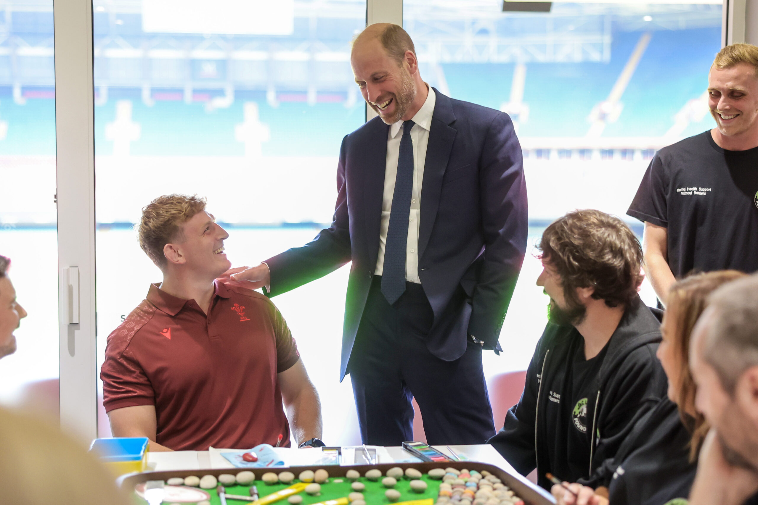 Prince William at a mental health hub, participating in arts and crafts with rugby player Jac Morgan.