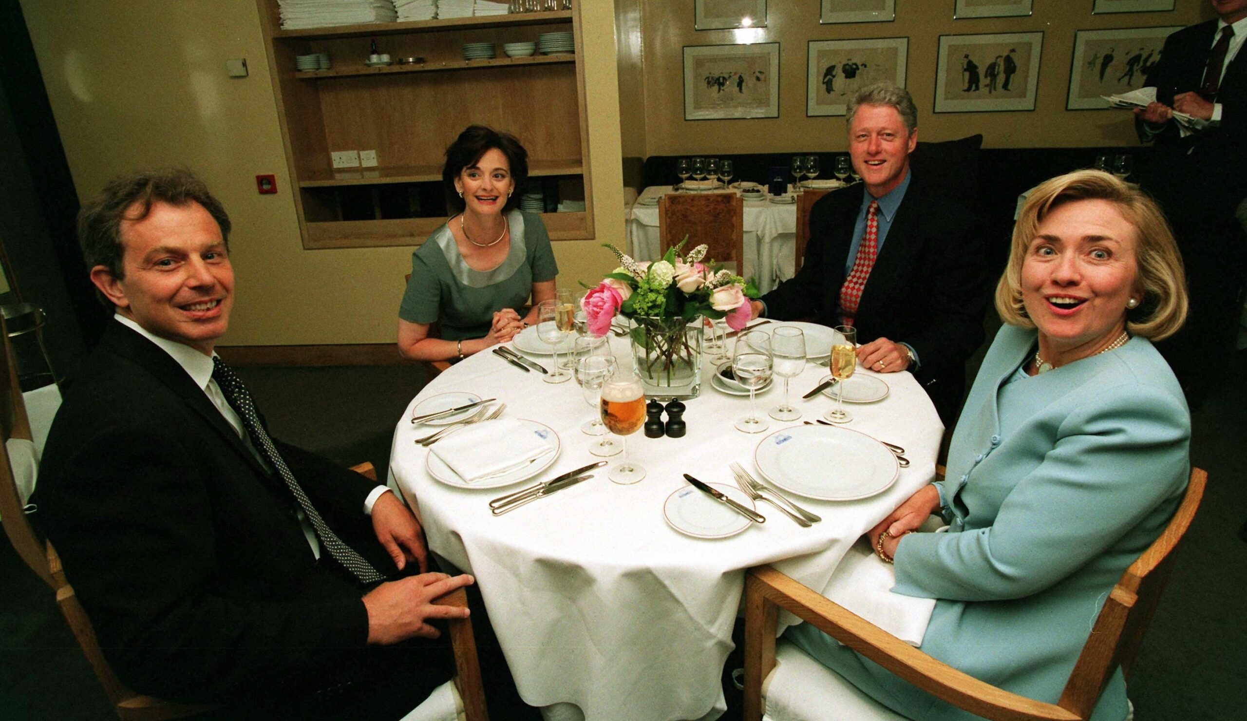 Bill Clinton, Hillary Clinton, Tony Blair, and Cherie Blair at a dinner.