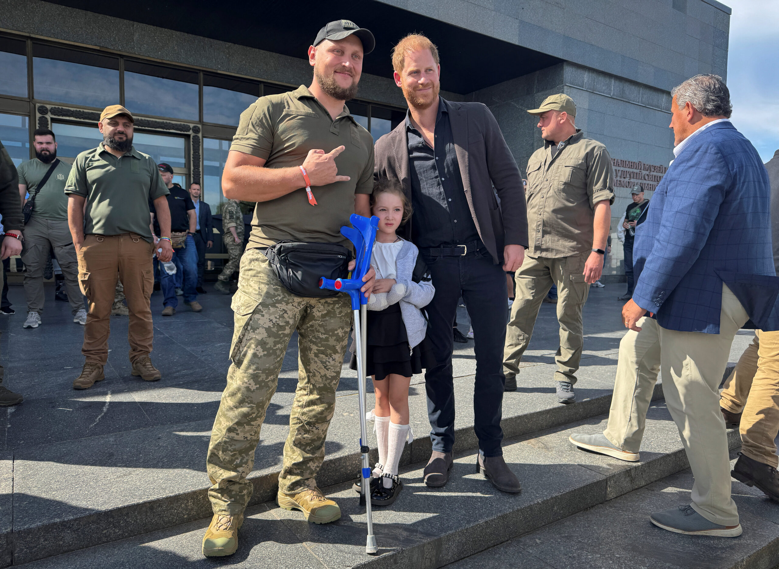 Prince Harry with a wounded Ukrainian serviceman and a young girl in Kyiv.