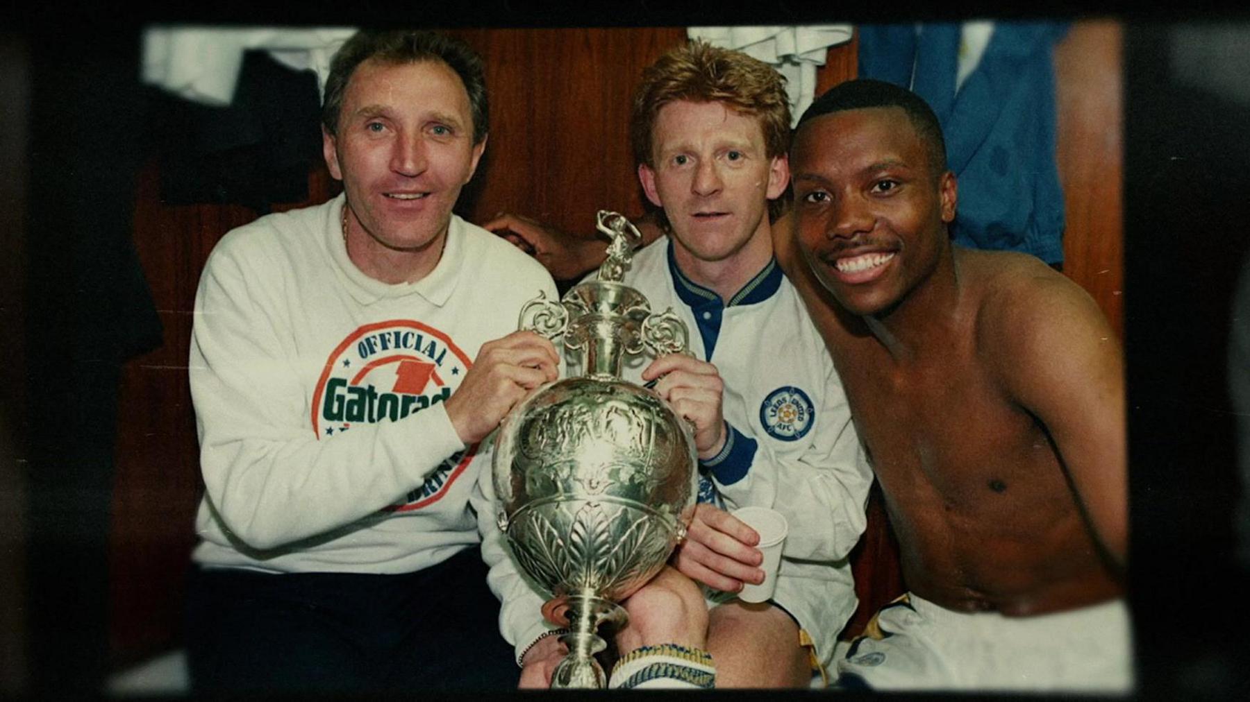 A photo of Howard Wilkinson, Gordon Strachan and Rod Wallace posing with the First Division trophy in the dressing room.