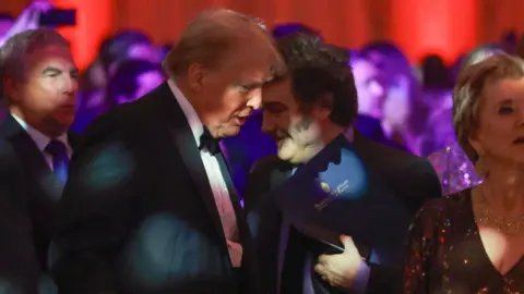 Getty Images Argentine President Javier Milei walks past U.S. President-elect Donald Trump as they attend the America First Policy Institute Gala held at Mar-a-Lago on November 14, 2024 in Palm Beach, Florida