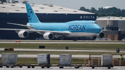 AFP A Korean Air Boeing 747-8I from Seoul, to repatriate hundreds of South Korean workers who were detained in an immigration raid at a Hyundai-LG battery plant under construction in the US state of Georgia last week, is seen in the cargo area of Hartsfield-Jackson Atlanta International Airport in Atlanta, Georgia, on 10 September, 2025.