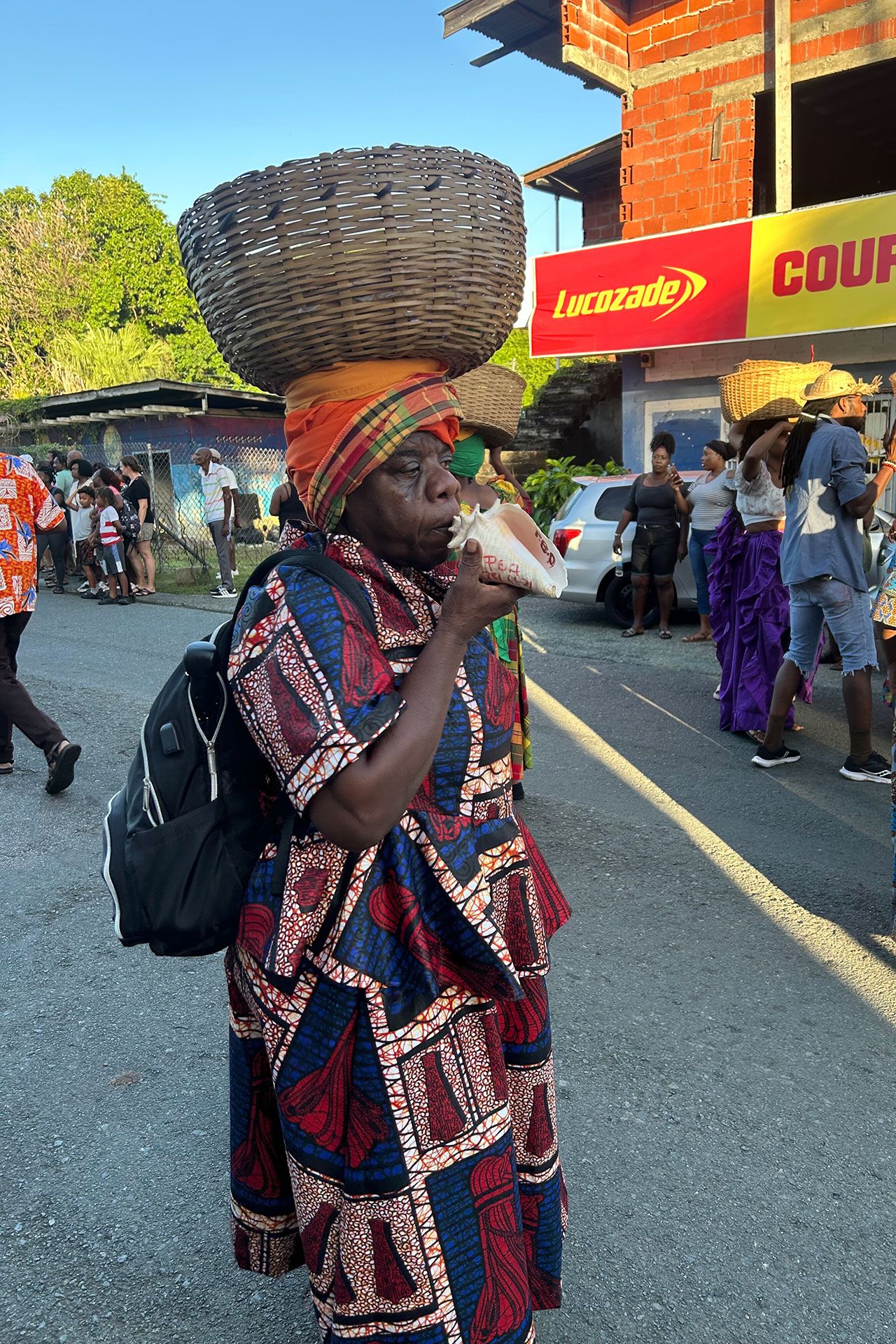 Woman blows a conch shell to announce the start of the performance