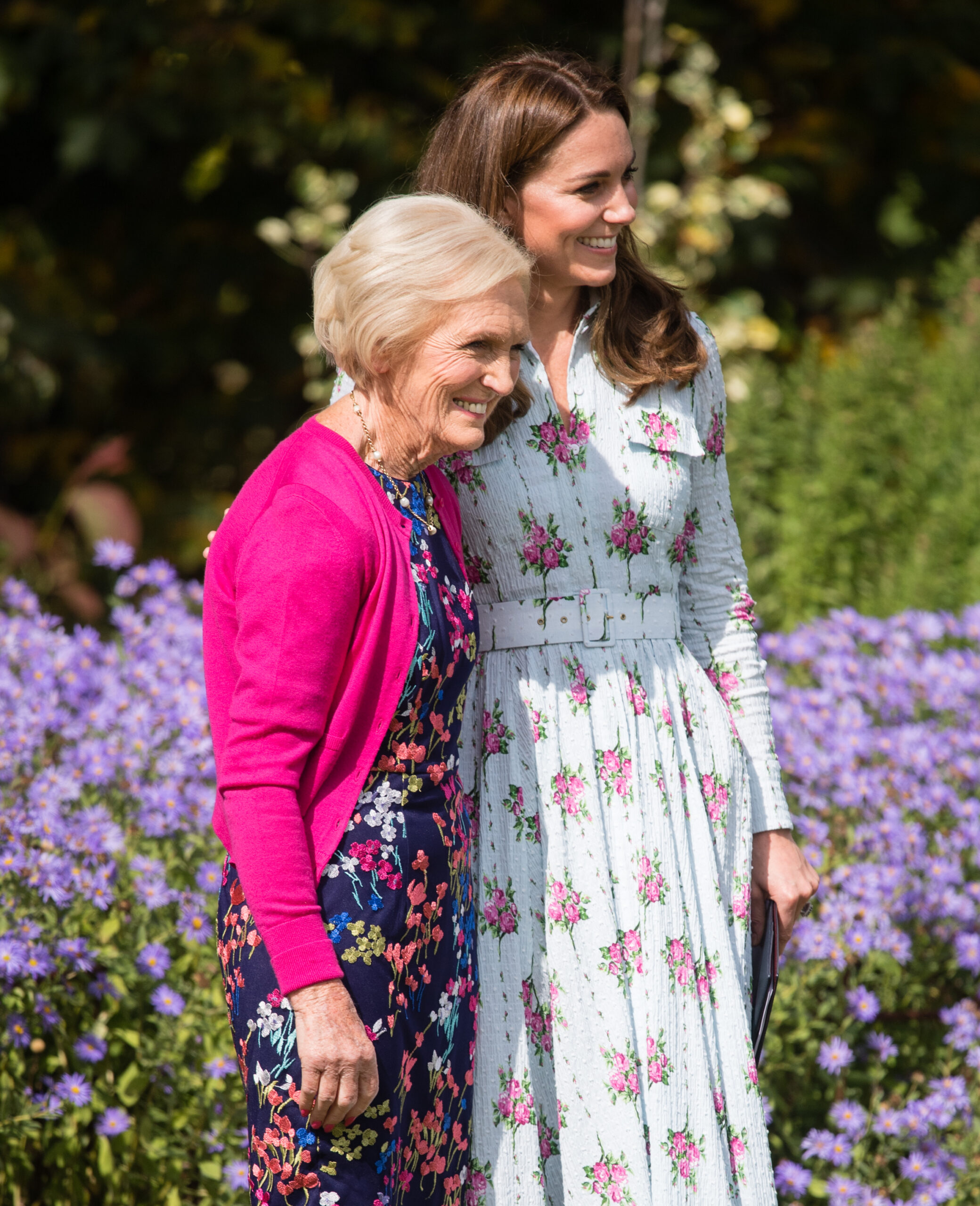 Mary Berry and Kate Middleton wearing floral dresses standing in a garden