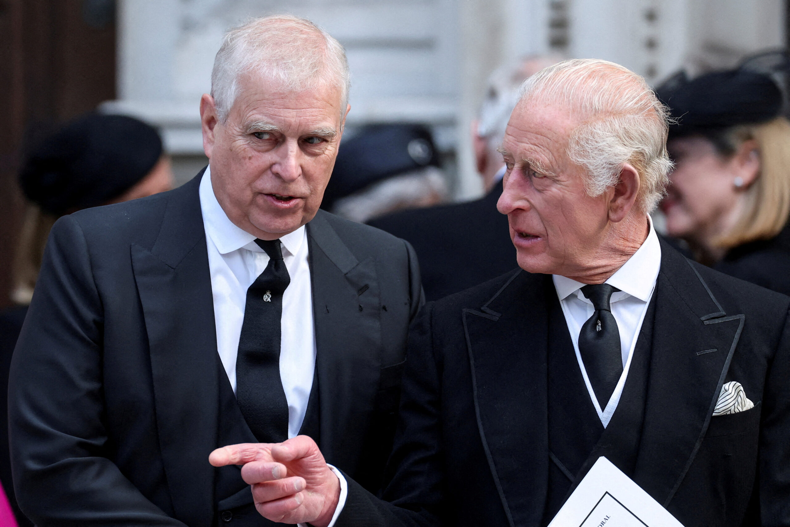 Prince Andrew speaks with King Charles outside Westminster Cathedral.