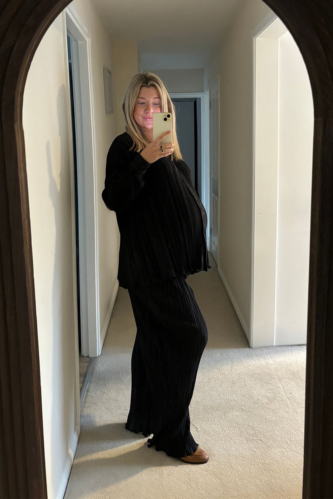 Image may contain Adult Person Standing Electronics Mobile Phone Phone Clothing Sleeve Accessories and Jewelry