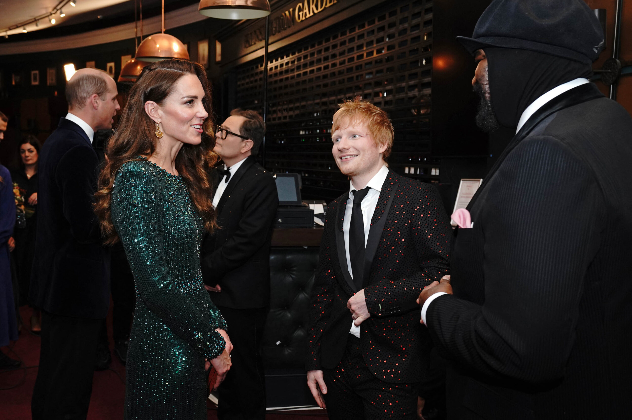 Kate Middleton wearing a green gown talking to Ed Sheeran