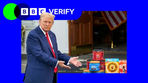 Getty Images Donald Trump in a suit gesturing towards grocery items
