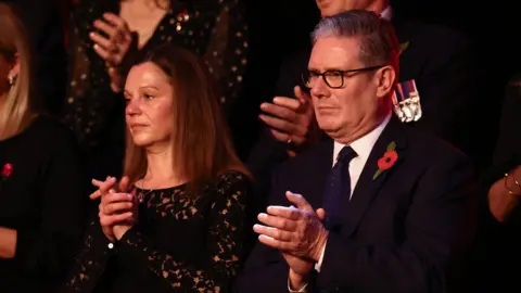 PA Media Sir Keir and Victoria Starmer both wear black and each wear a poppy at the remembrance event.