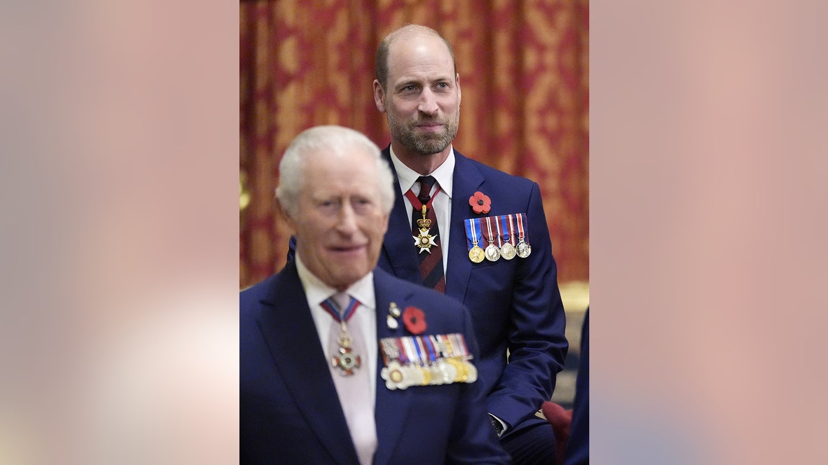 Prince William standing being King Charles as they sport matching dark blue suits with medals.