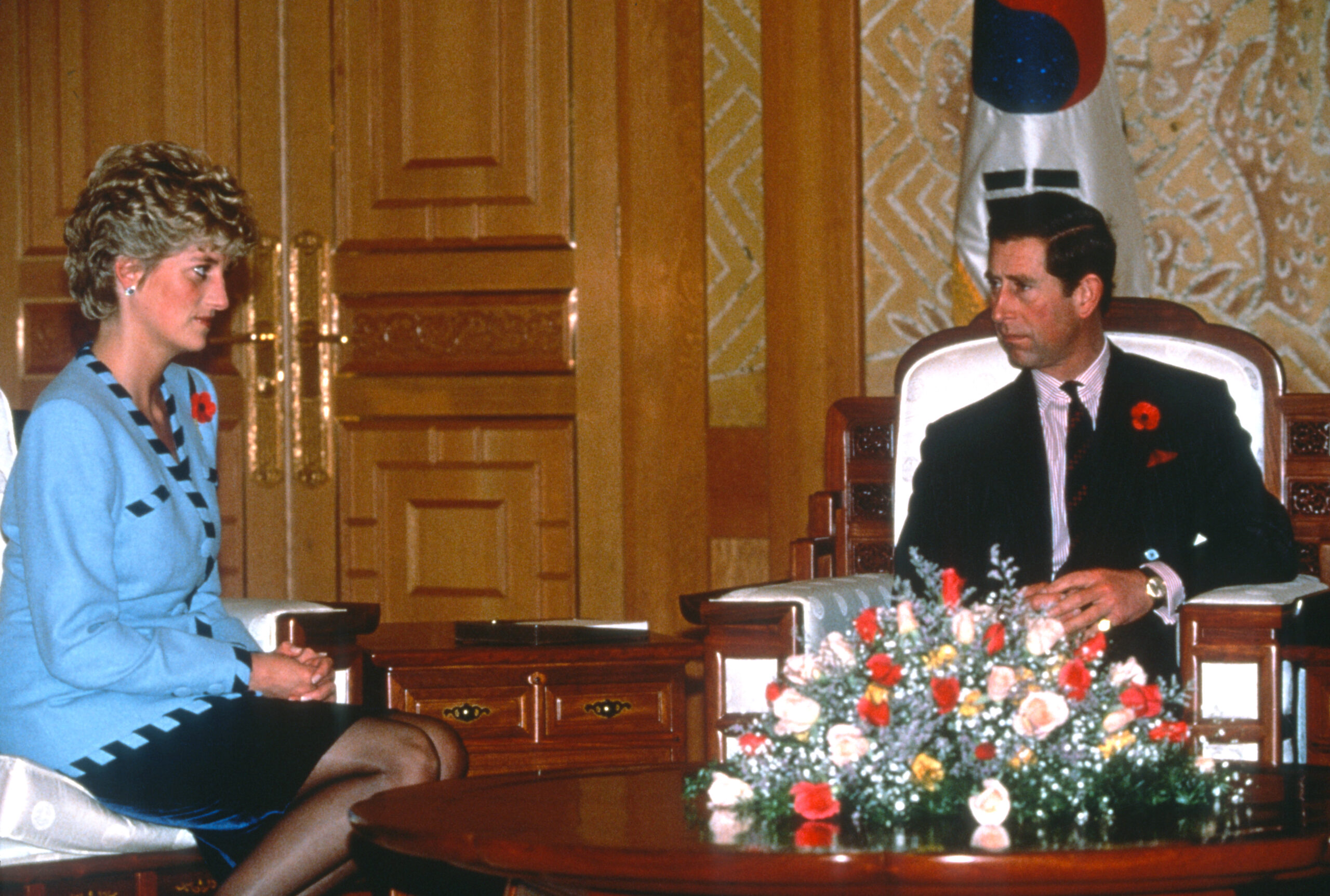 Princess Diana and Prince Charles sitting across a table from each other in South Korea
