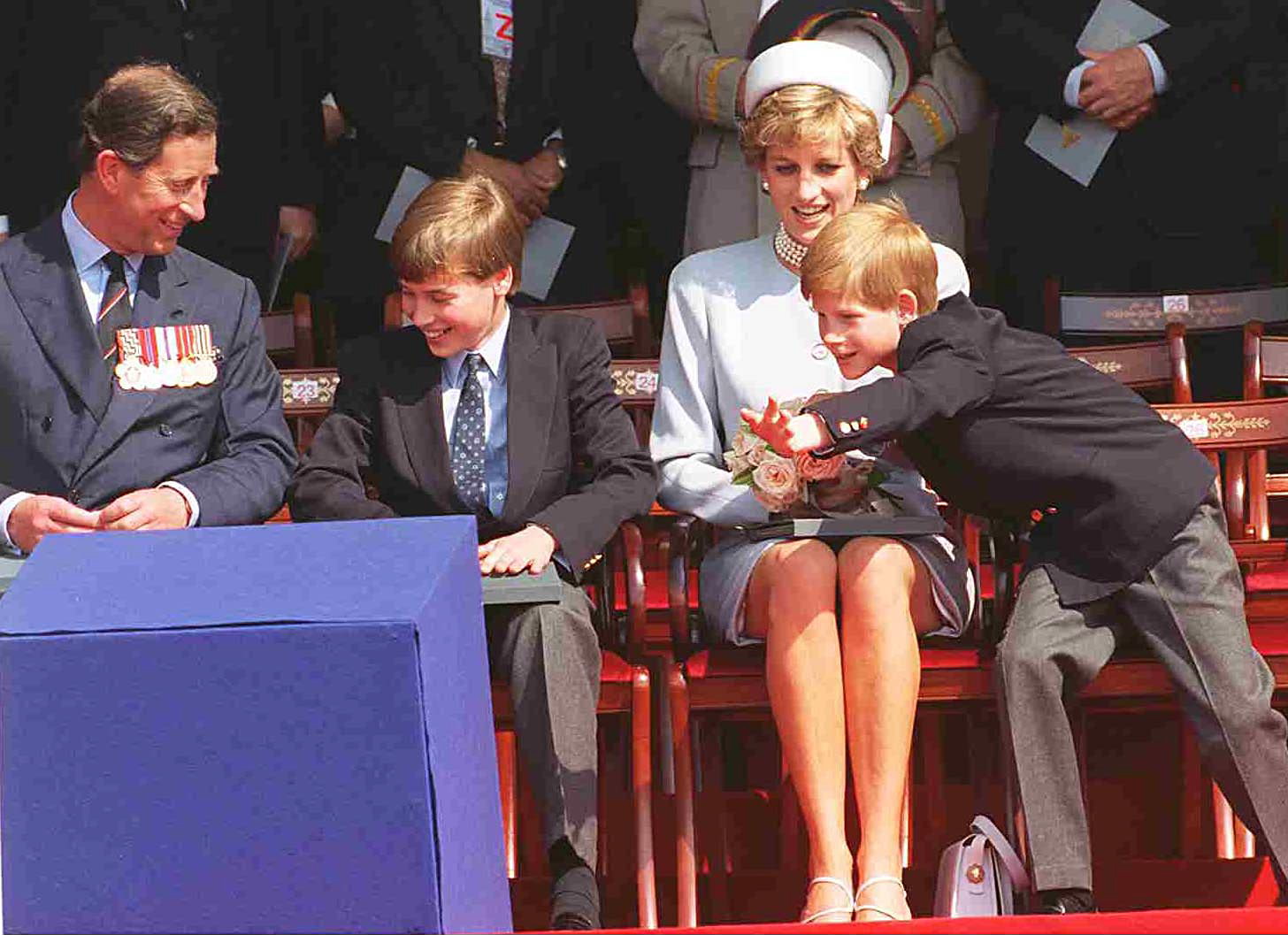 Prince Charles, Prince William, Princess Diana and Prince Harry sitting next to each other at a 1995 VE Day event