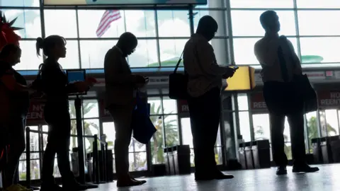 Getty Images People walking in front of a terminal building