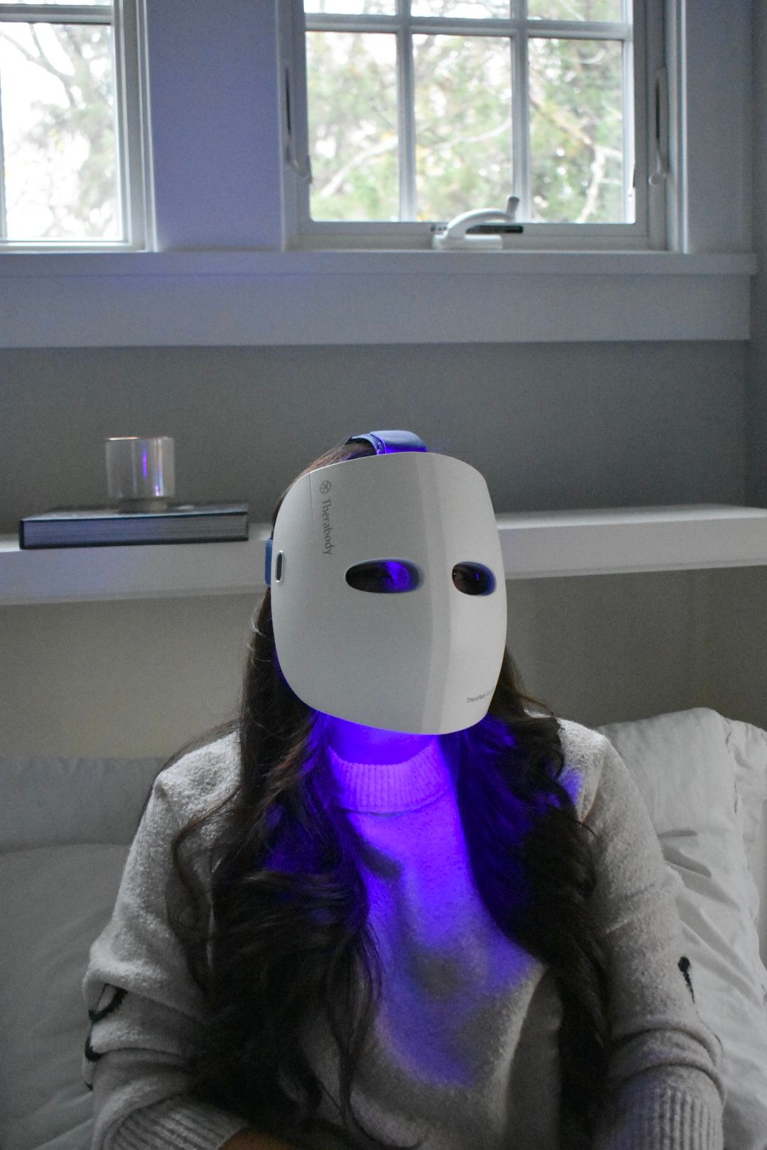 Allure contributing commerce writer Christa Joanna Lee using the TheraFace Mask Glo in blue light mode