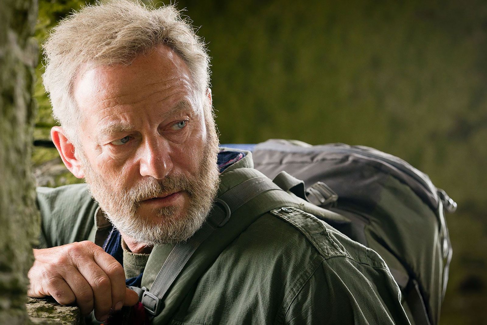 Image may contain Jason Isaacs Clothing Coat Jacket Photography Beard Face Head Person Portrait Adult and Bag