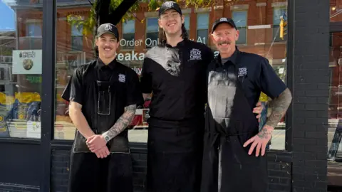 Mark Michelin Mark Michelin and his two sons outside of their shop