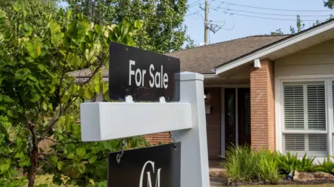 Houston Chronicle via Getty Images A for sale sign is seen in front of a house.