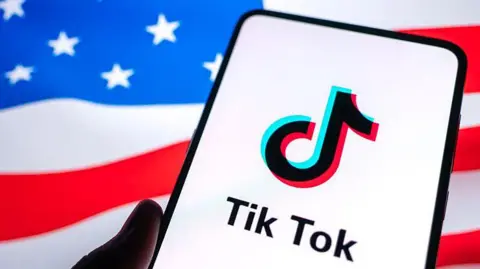 VCG via Getty Images TikTok logo a smartphone screen with a US flag in the background.