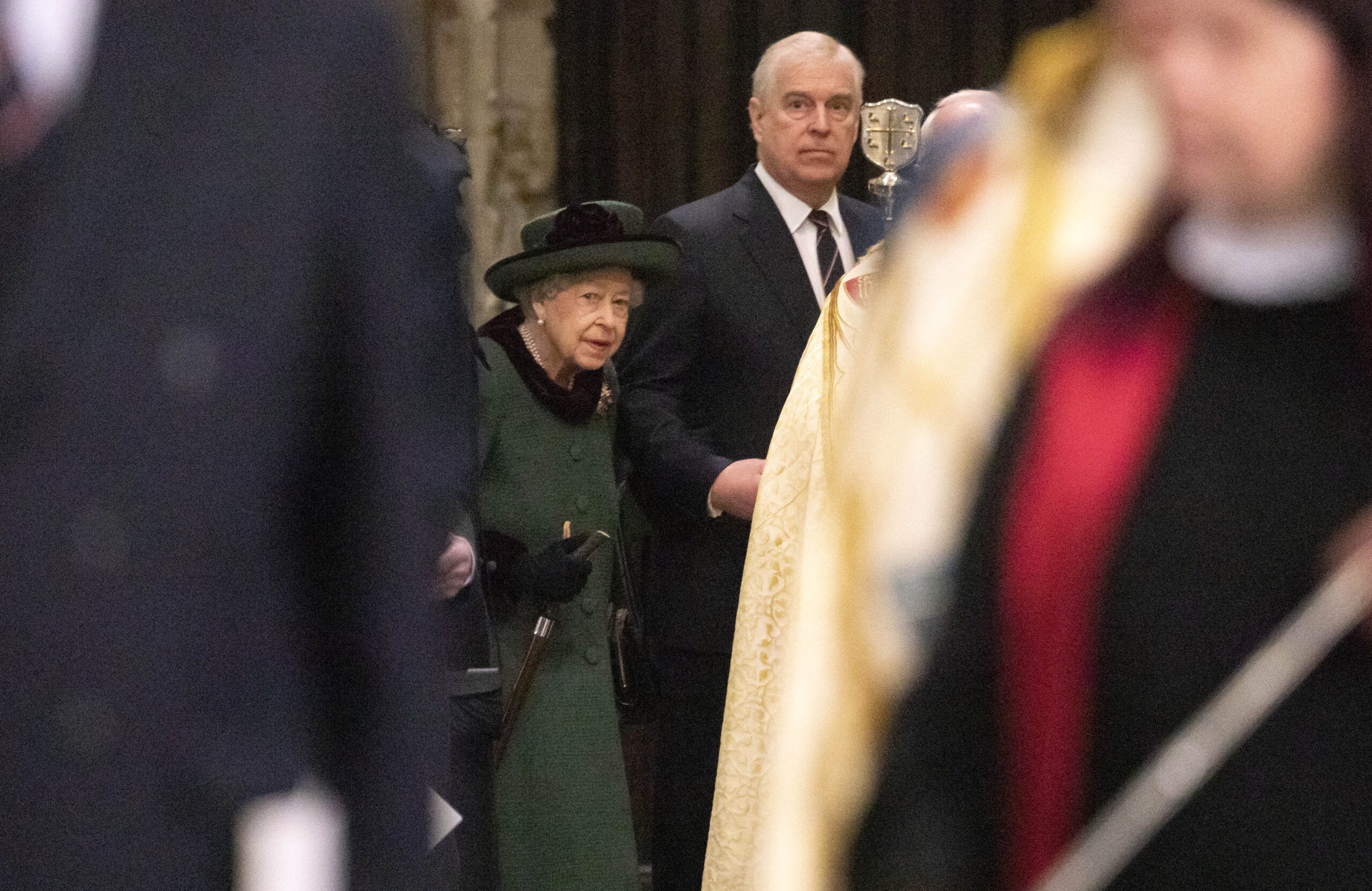 Queen Elizabeth wearing a green coat on the arm of ex-Prince Andrew at a service of Thanksgiving in 2022