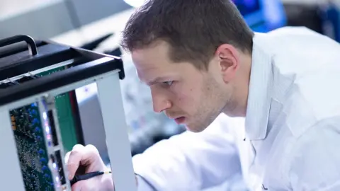 Julien Lutt / CAPA Pictures Thales employee dressed in lab coat working on development of surveillance and air defense radars at Limours Thales site.