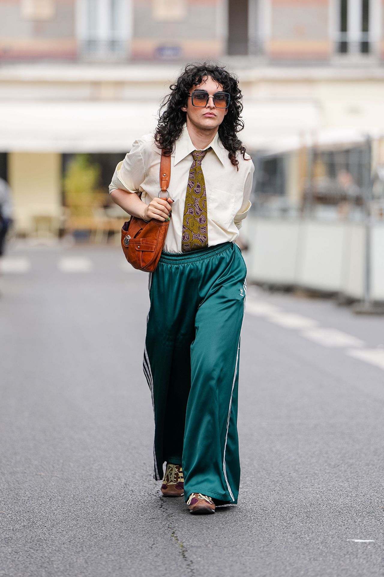 Image may contain Clothing Pants Hair Person Curly Hair Adult Accessories Formal Wear and Tie