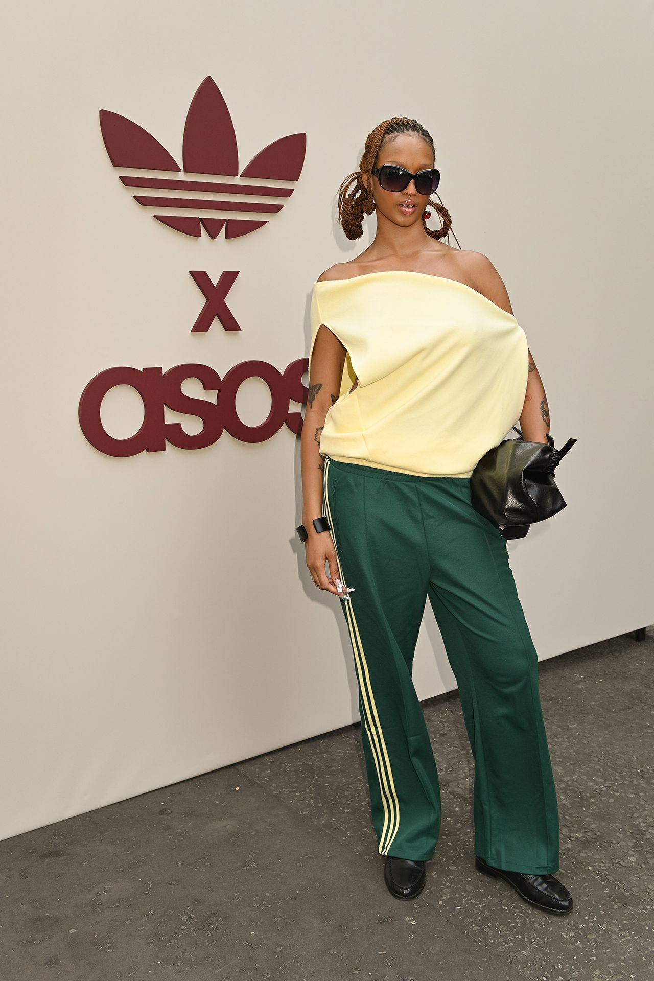 Image may contain Clothing Pants Sleeve Blouse Accessories Bag Handbag Adult Person Standing and Sunglasses