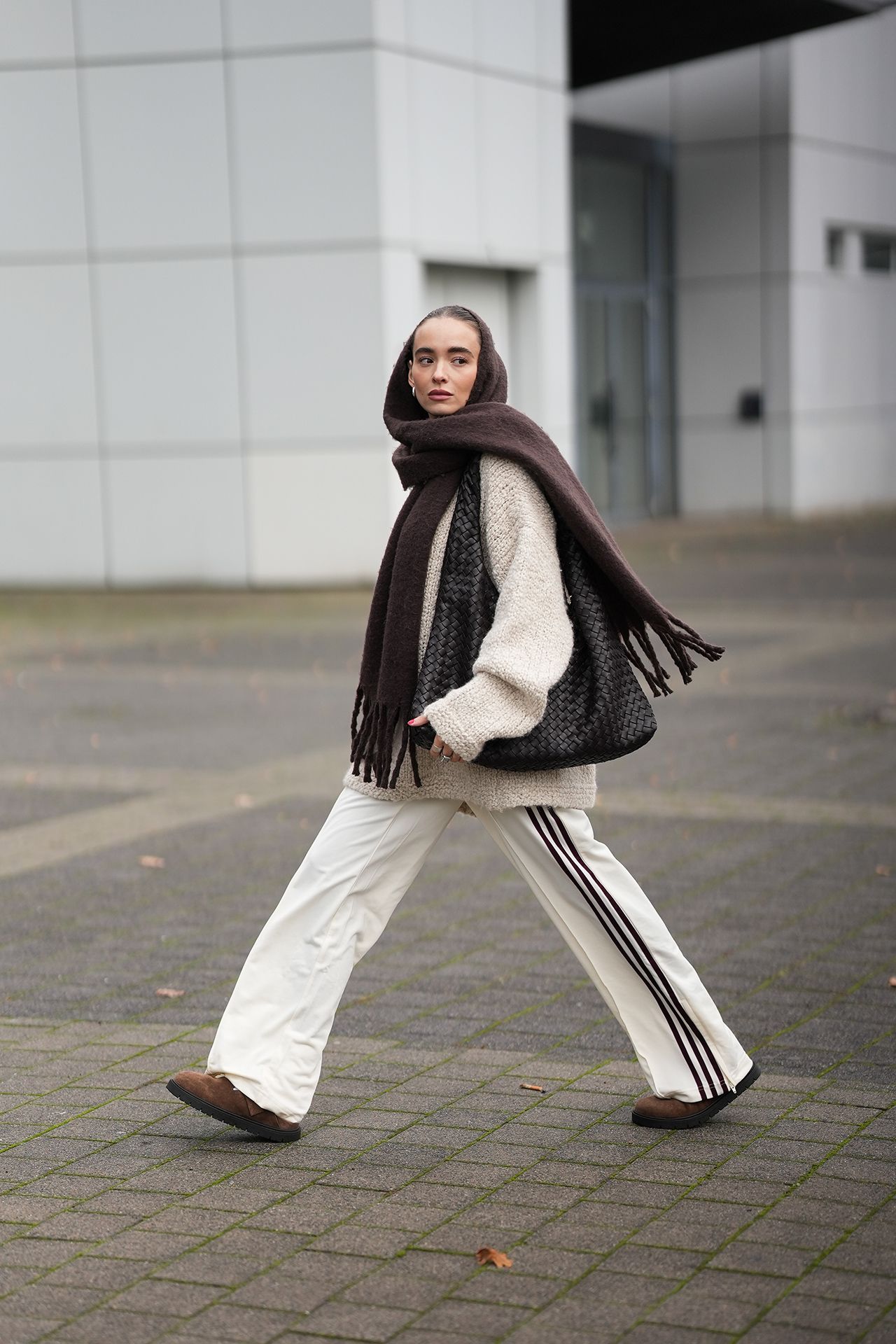 Image may contain Person Walking Pedestrian Adult Clothing Pants Scarf and Standing