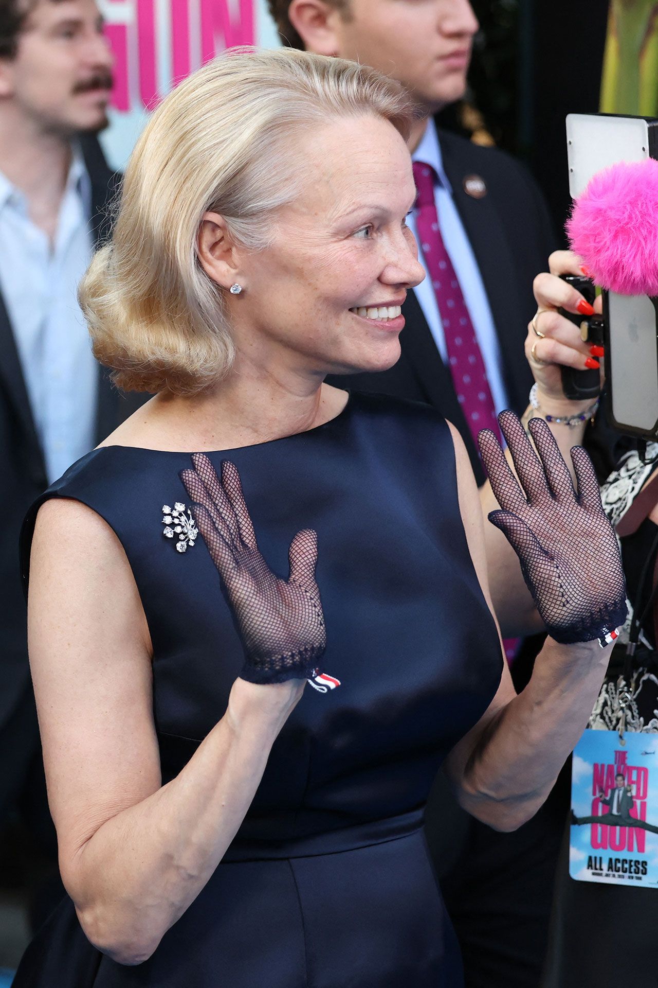 Image may contain Pamela Anderson Person Adult Clothing Glove Body Part Finger Hand Accessories and Formal Wear