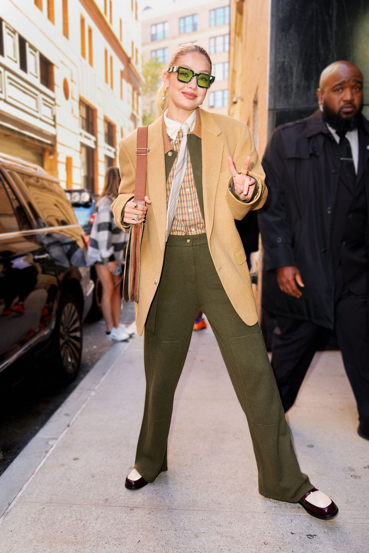 Image may contain Gigi Hadid Blazer Clothing Coat Jacket Formal Wear Suit Person Walking Adult City and Pants