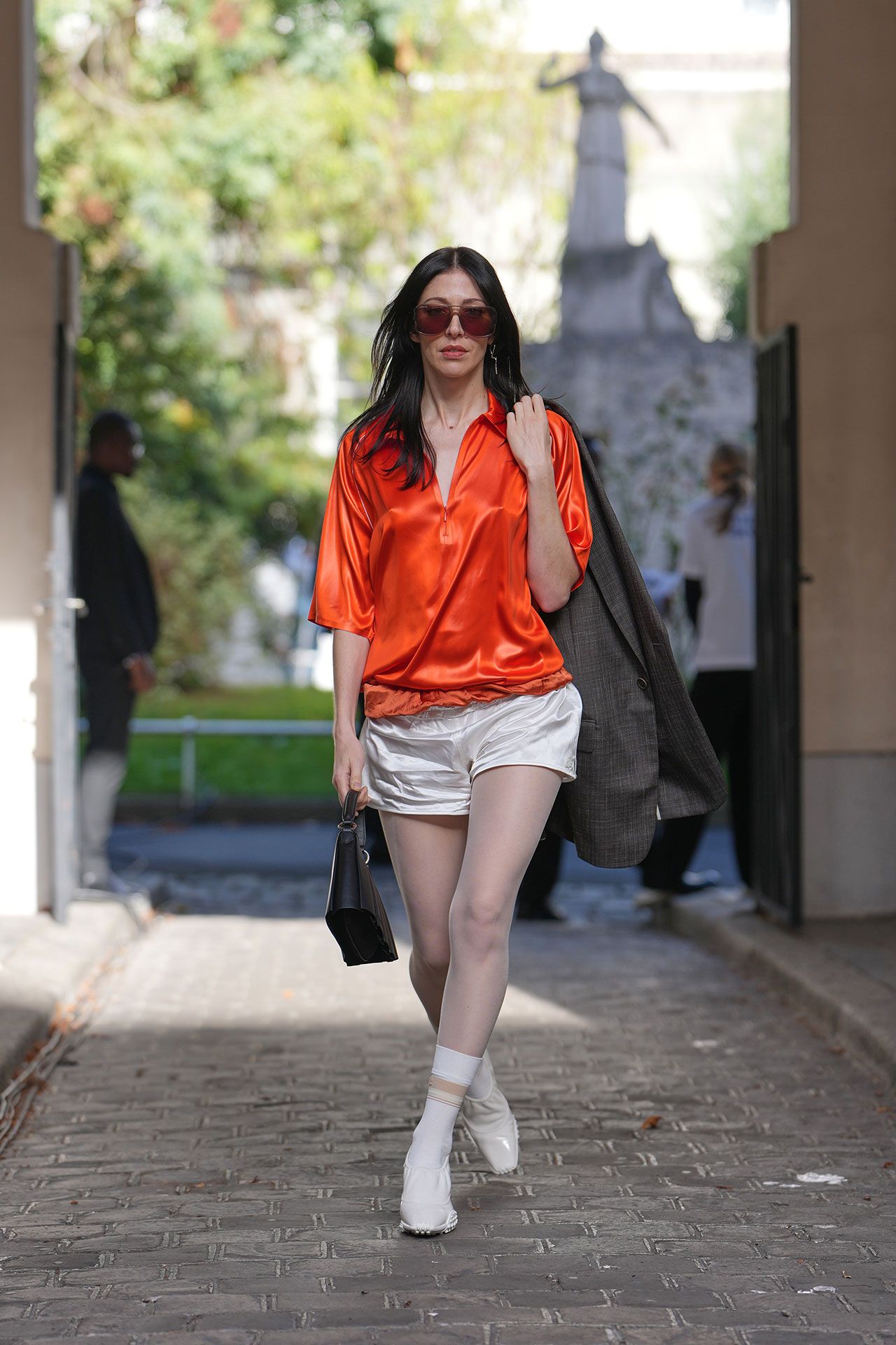 Image may contain Caroline Polachek Pedestrian Person Adult Clothing Shorts Accessories Bag Handbag Teen and Coat