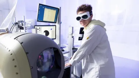 Julien Lutt / CAPA Pictures Employee dressed in a lab coat working at the Thales Elancourt site