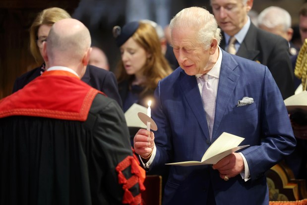 Britain's King Charles III holds a candle as he attends an Advent Service at Westminster Abbey, in London, Wednesday, Dec. 10, 2025. (Chris Jackson/Pool Photo via AP)